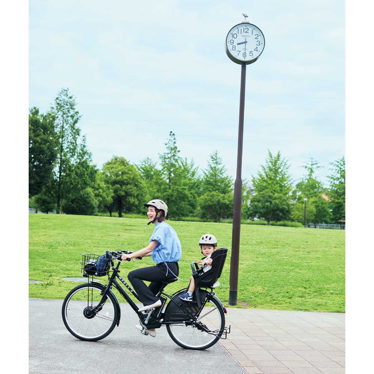 UV機能付きシャツにパンツルックで自転車に乗るママ