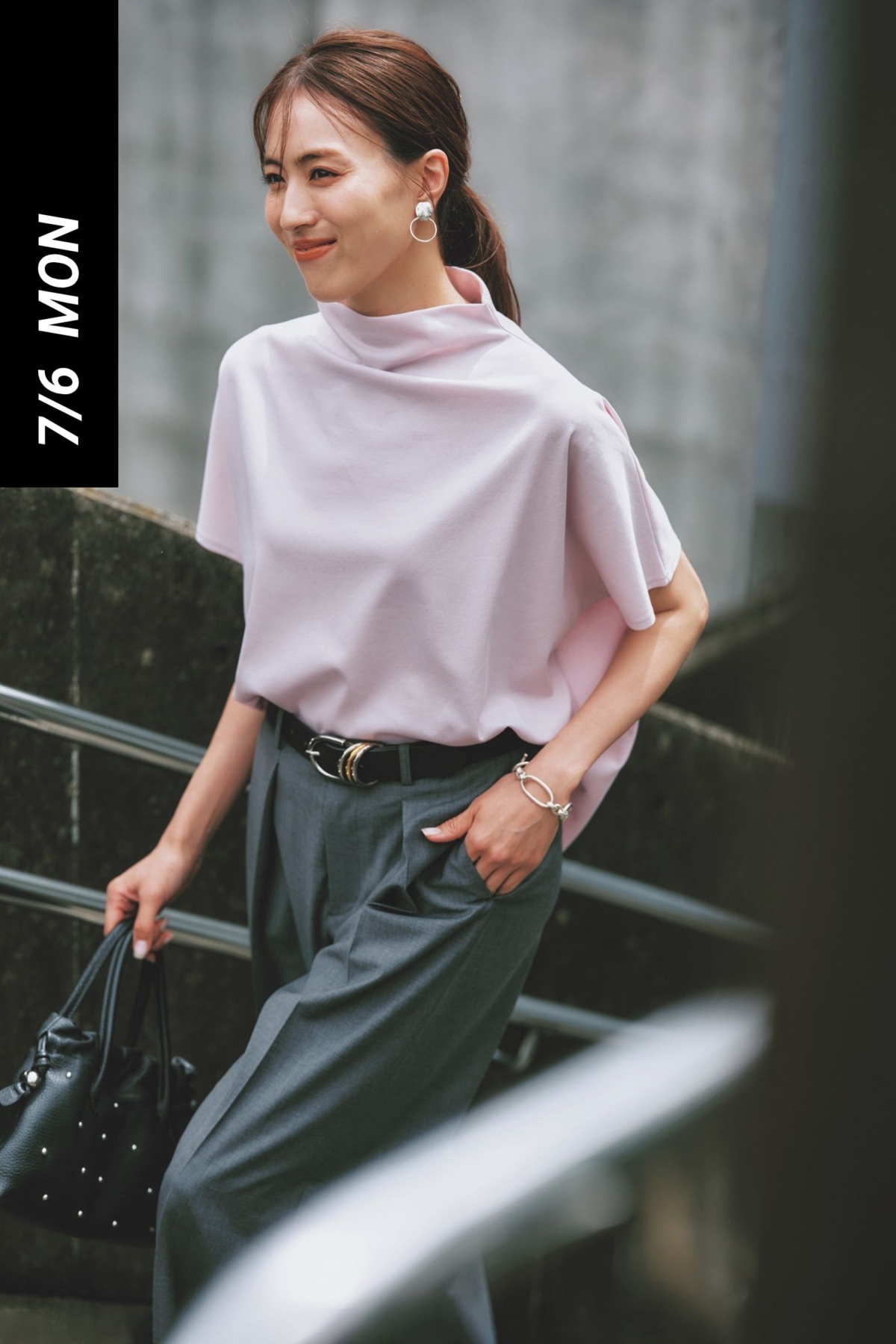 ライラックカラーのボトルネックTシャツとグレーのスラックスを合わせたキレイめコーデ
