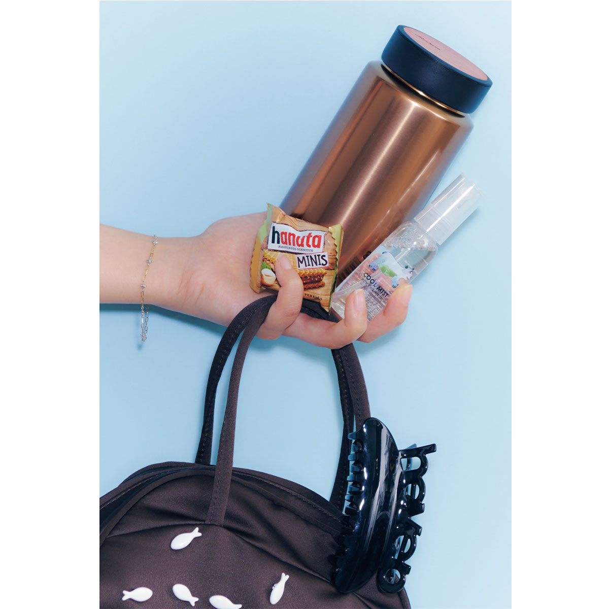 MOKU COFFEEのボトルとバッグ、お菓子を手に持つイメージカット