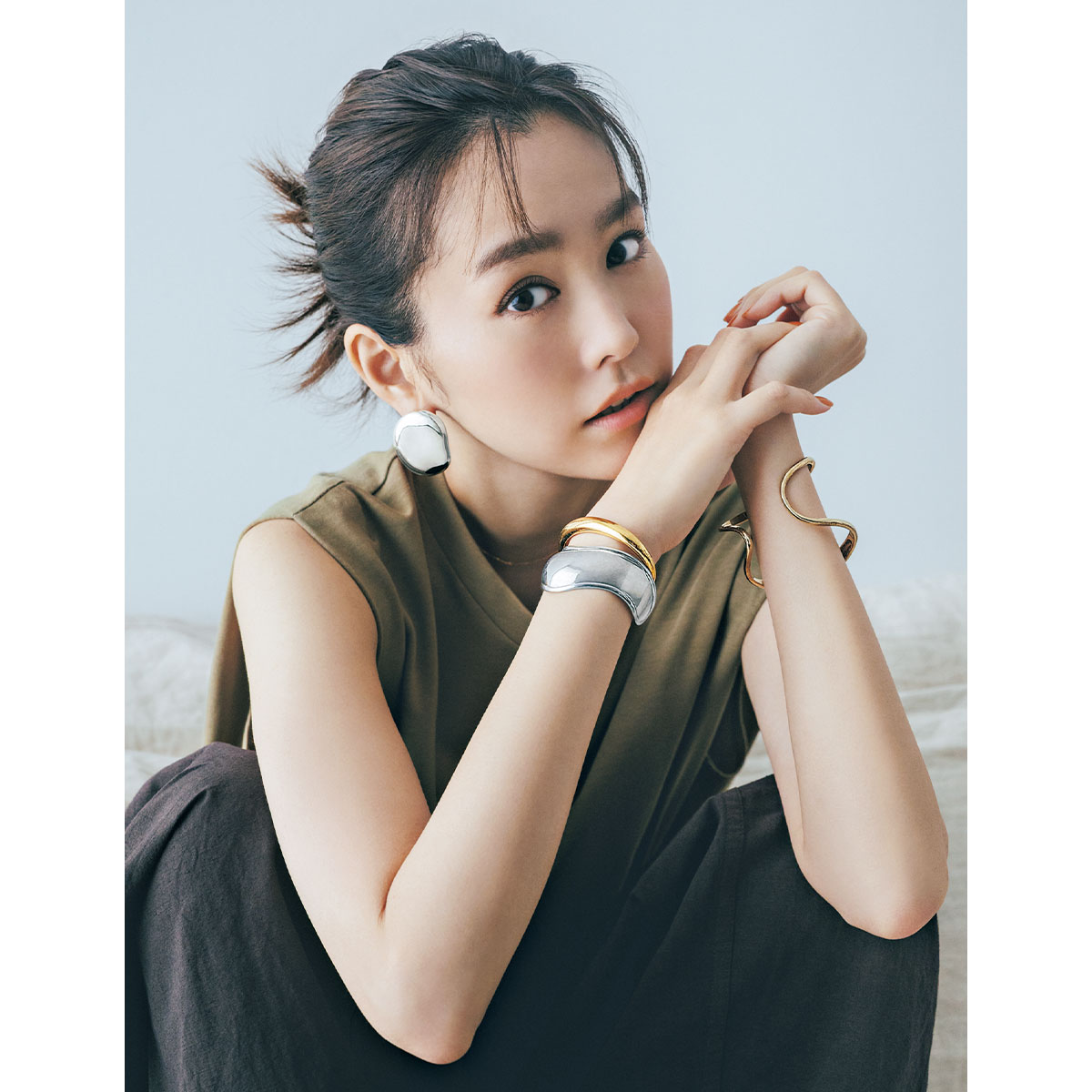 ジャミレイのゴールドとシルバーのバングルと大ぶりピアスをした桐谷美玲さん