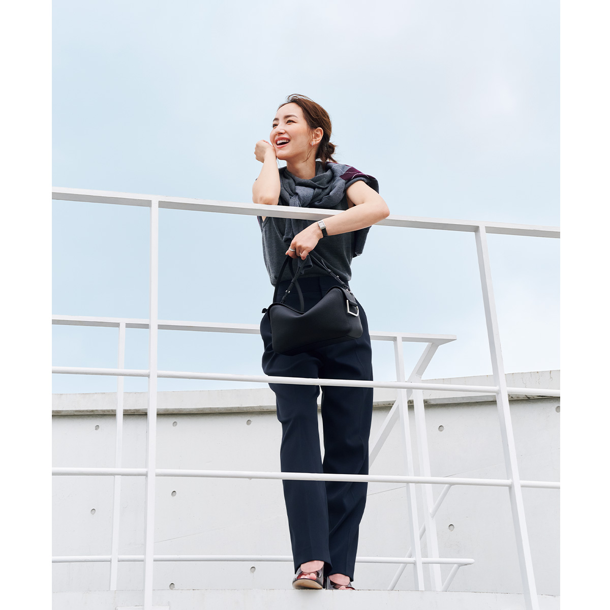 ノースリーブニットにアーガイル柄ニットを肩掛けしてパンツを合わせたコーデ