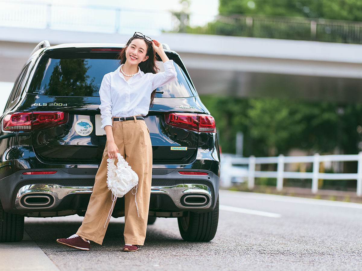 白シャツとチノパンコーデで愛車の前でポーズをとる古谷有美さん