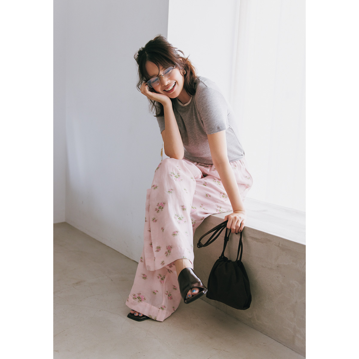 花柄パンツとグレーのTシャツを合わせたコーデにリムレスメガネをジュエリー感覚でON
