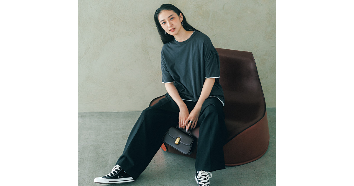 ゆるっとしたTシャツとスラックスの足元に黒のコンバースを合わせた武井咲さん